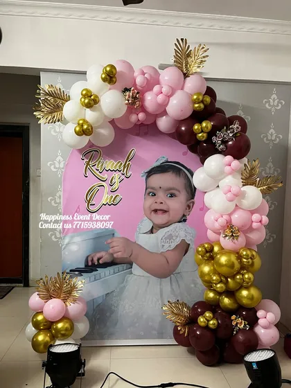A closer look at the premium U-shaped balloon decor, showing the detail of the gold and maroon chrome balloons against the personalized backdrop.