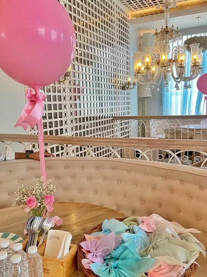Table setting for the bridal shower, featuring a large pink balloon and a small floral arrangement. Even small details are coordinated to create a cohesive and beautiful event space.