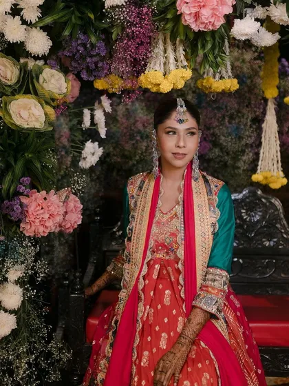 The full view of this stunning mehendi look, set against a beautiful floral backdrop.