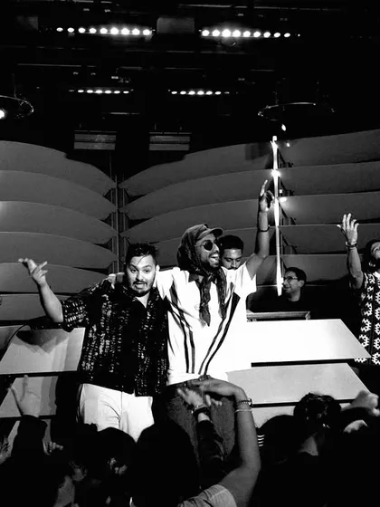 A black and white shot of the whole crew on stage in NYC at the end of the night. It captures the sense of community and shared accomplishment after a successful event.