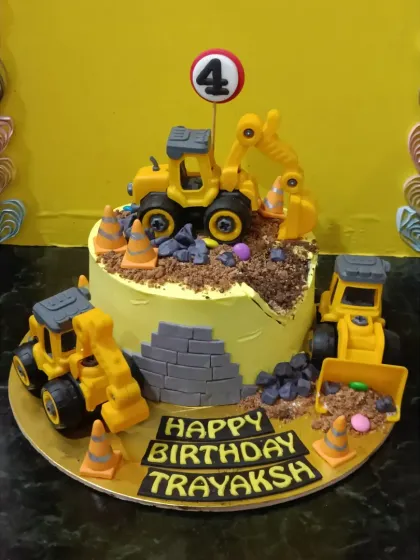 A dream cake for a little builder. This construction-themed cake features toy excavators digging into chocolate "dirt" and crushed Oreo "rubble."
