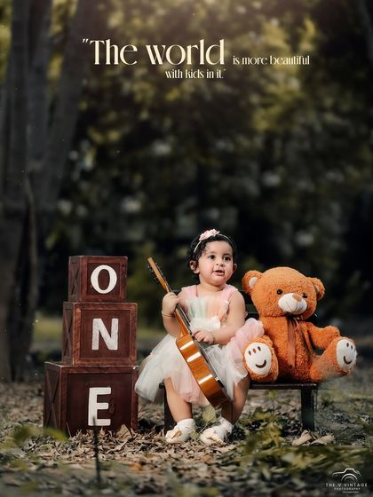 The world is more beautiful with kids in it. A lovely outdoor portrait of a little girl with her teddy bear and ukulele, celebrating her first birthday.