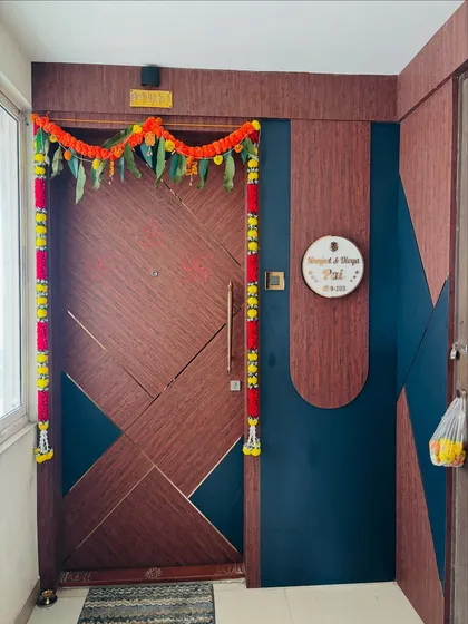 The full entrance view, showing the beautiful main door, custom nameplate, and the surrounding wall paneling.
