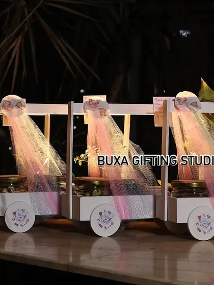 A row of the finished baby shower carts at the event venue, creating a beautiful and impressive display for guests to take home.