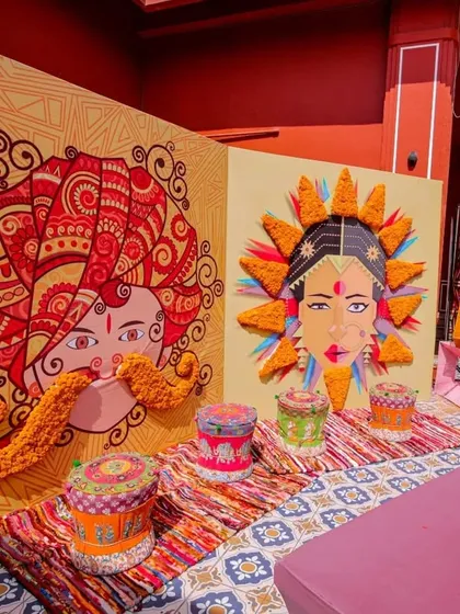 A quirky and colorful photo-op designed for a vibrant Mehendi. This backdrop features pop-art style illustrations of a bride and groom, adorned with real marigold flowers.