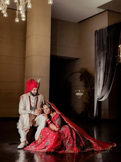 A tender moment between the couple, seated together in a grand, beautifully lit hall. This shot feels intimate and royal.