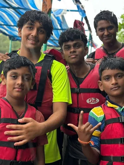 A group of friends poses for a photo, geared up in life jackets and ready for their kayaking adventure in Malpe.