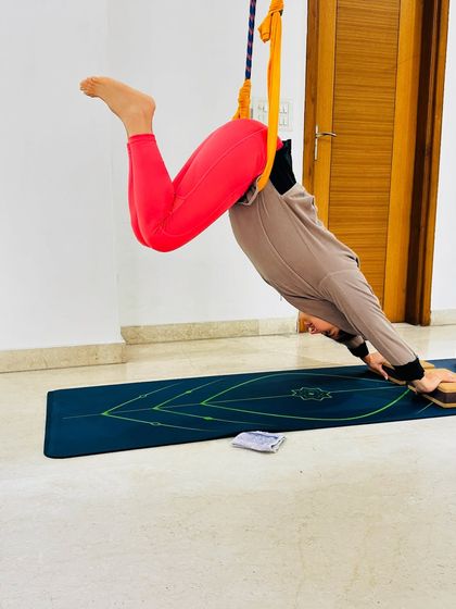 Using the yoga wall ropes for a suspended Downward Dog variation allows for deep spinal traction and shoulder opening. This is a fantastic way to explore familiar poses in a new way.