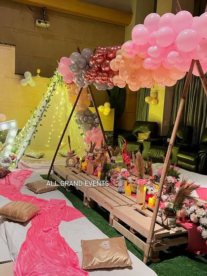 The full boho picnic arrangement, showing the low tables on artificial grass, surrounded by cushions for a comfortable and stylish gathering.