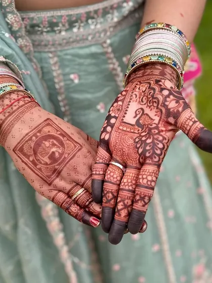 A beautiful combination of motifs on each hand. One palm features a traditional elephant design, while the other showcases an elegant peacock, giving the bride a unique and varied look.