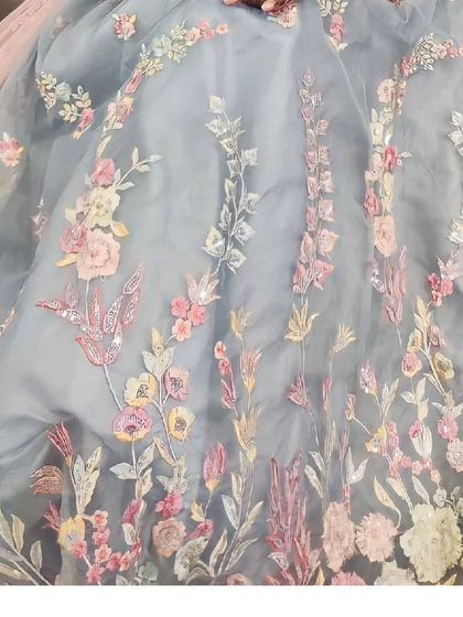 A close-up of the delicate multi-color floral embroidery on this powder blue lehenga. The craftsmanship is what sets our collection apart.