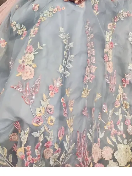A close-up of the delicate multi-color floral embroidery on this powder blue lehenga. The craftsmanship is what sets our collection apart.