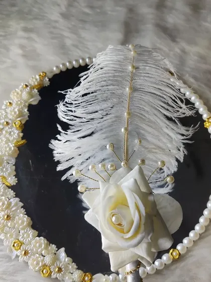 A final look at the white elegance set, focusing on the texture of the feather and the shine of the pearls.
