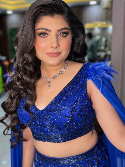 A gorgeous look in a stunning royal blue outfit. The makeup is bold and beautiful, with a focus on the eyes.