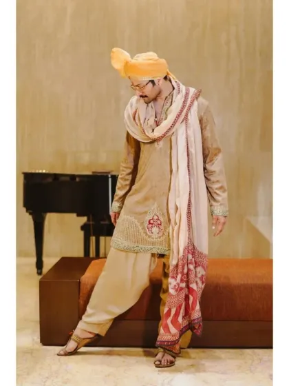 A stylish pose from the groom, showing off the flow and design of his wedding attire. This shot adds a touch of fashion and personality to his wedding album.