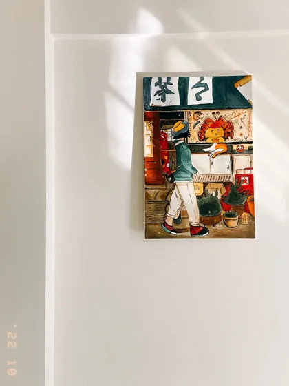 The illustrative painting displayed in a room, showing how it looks as a piece of home decor, catching the natural light from a window.