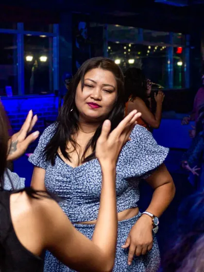 A woman enjoying the music on a packed dance floor. The energy of the crowd is a huge part of the experience.