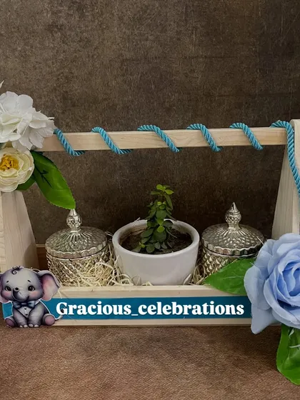 This versatile wooden tray hamper can be customized for any occasion. Here, it's decorated in a lovely blue theme, perfect for a wedding giveaway, with crystal jars and a central planter.