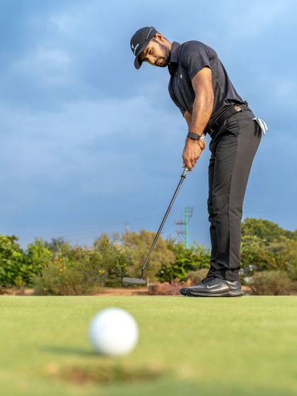 A low-angle view of a player lining up a putt. We teach green reading and stroke mechanics to help you sink more putts under pressure.