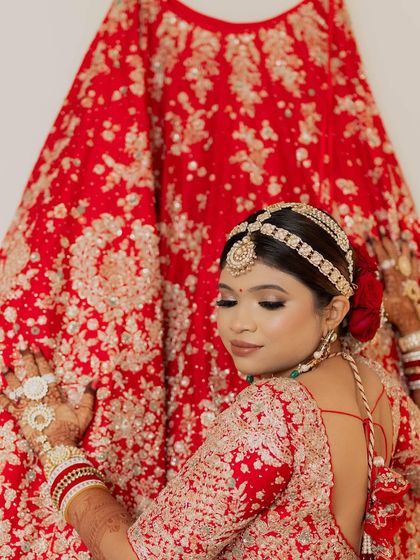 A creative shot of the bride with her red wedding lehenga. I styled her hair in a classic bun, adorned with a beautiful matha patti.