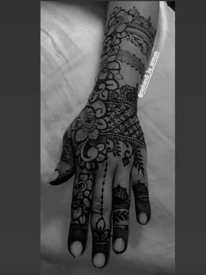 A black and white version that emphasizes the detailed line work and shading in this full-coverage henna design.