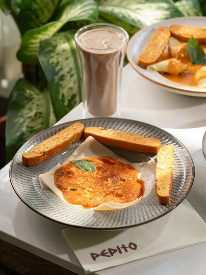 A unique "pasta handkerchief" dish with garlic bread. This showcases a more unconventional pasta dish.