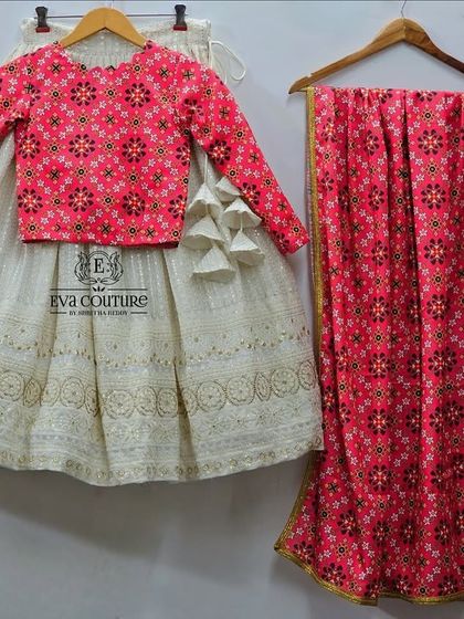 A beautiful twinning lehenga set featuring a white chikankari skirt paired with a pink printed long-sleeve blouse and a matching dupatta. This design is perfect for a coordinated and elegant family look.