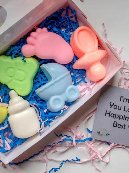 These baby shower themed soap boxes make for wonderful return favors. Each box contains a set of handcrafted soaps shaped like a baby foot, a rattle, and a bottle, made with gentle Shea Butter and Coconut Oil.