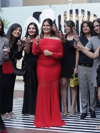 The bride-to-be surrounded by her tribe, all raising a custom shot in her honor.