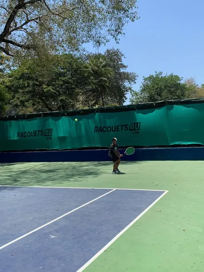 A player watches the ball intently, preparing for a backhand shot during a match at our academy.