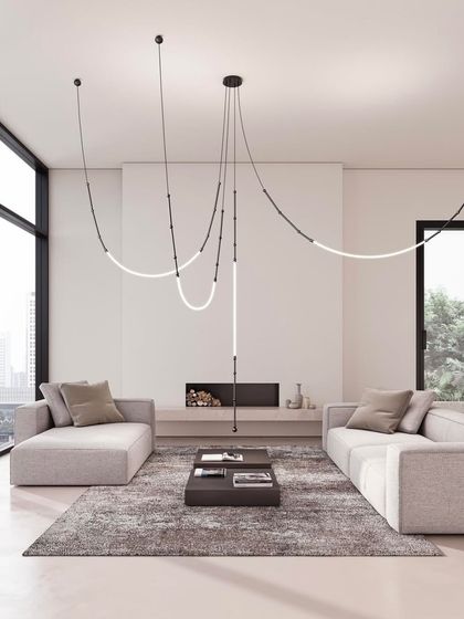A sprawling Leda installation serves as the primary light source in a large, minimalist living room, its form drawing the eye and connecting the different areas of the space.