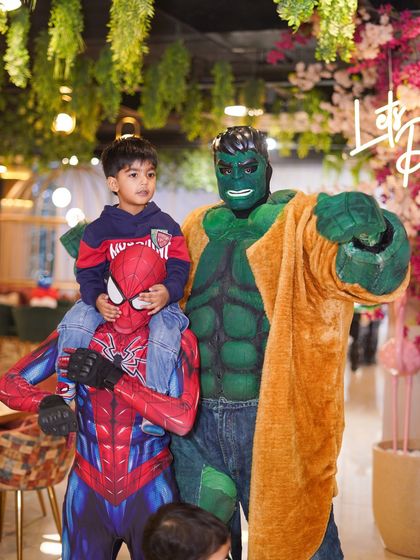 The birthday boy gets a lift from his hero, Spider-Man, while the Hulk stands by. These interactive moments with characters make our parties truly special.
