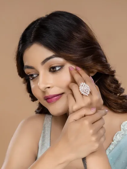 This image highlights a large, floral-designed cocktail ring. The model's hand placement draws the eye directly to the ring, making it a perfect shot for featuring a hero product.