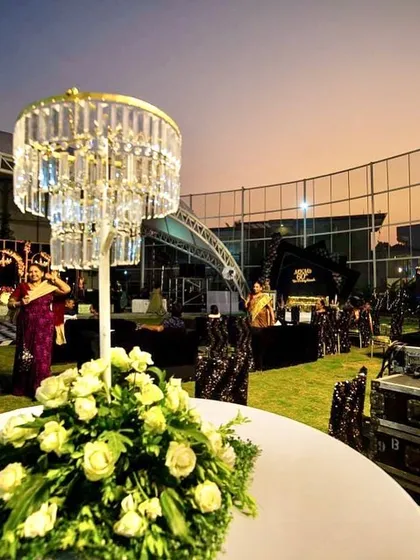 An evening view of the outdoor event, with our custom chandelier centerpieces lighting up the tables.
