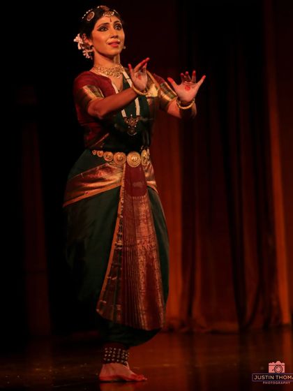 The 'pataka hasta' or hand gesture with a flat palm, used here to signify assurance or blessing. Hand gestures, or mudras, are the vocabulary of Bharatanatyam.
