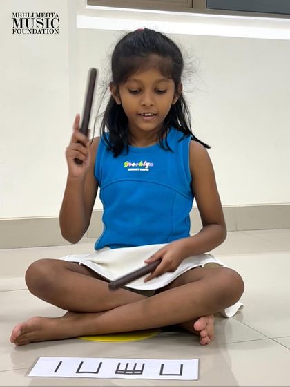 This student confidently holds her claves, demonstrating her readiness to perform the rhythm. Our goal is to build both musical skill and self-assurance.