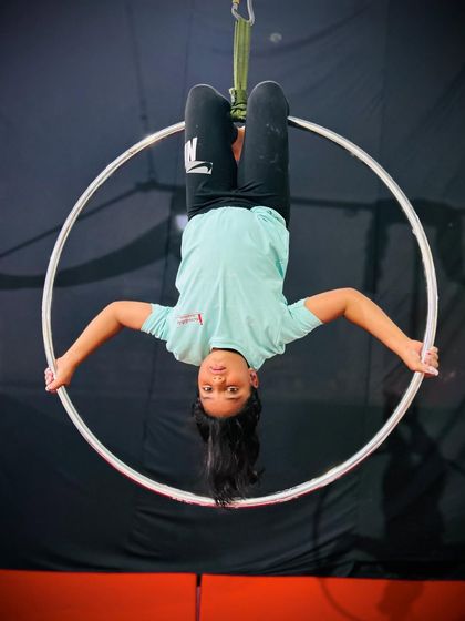 An inverted hang from the top of the hoop is a great way to build grip strength and get comfortable being upside down.