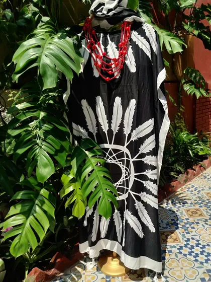 This black and white feather-print kaftan is a standout piece from the Autumn collection. Paired with a bold red necklace, it creates a dramatic and stylish look that is also incredibly comfortable.