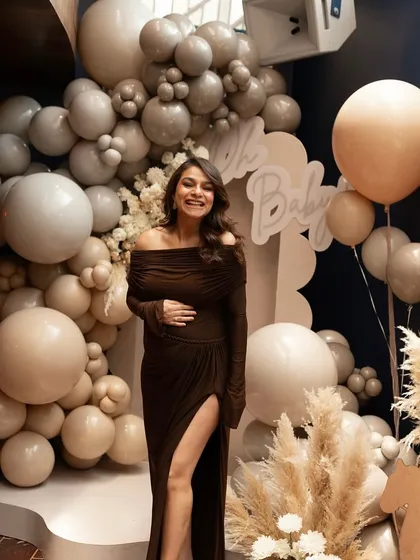 The most rewarding part of my work is seeing the joy on my clients' faces. Here, the beautiful mother-to-be glows in front of the neutral-toned, teddy bear-themed baby shower backdrop I designed for her special day.