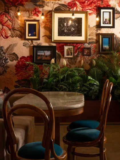 Another look at the maximalist corner at Echoes. The combination of bold wallpaper, eclectic art, and rich teal velvet chairs creates a space that is full of character and visual interest.