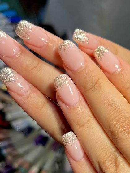Elegance with a touch of glitter. This beautiful ombré glitter effect fades from a dense silver sparkle at the tip to a sheer nude base, creating a sophisticated and glamorous look.