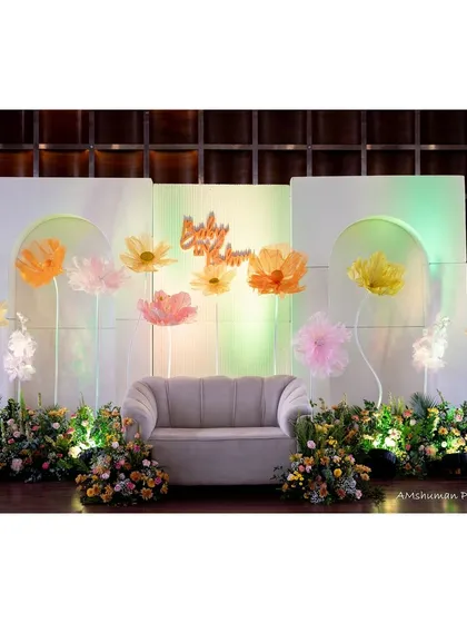 The main stage for a "Baby in Bloom" themed baby shower. We used a clean, modern backdrop with oversized paper flowers and soft, ambient lighting to create a beautiful focal point for photos and celebrations.