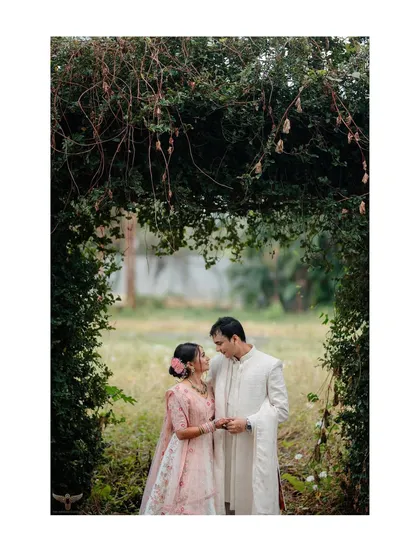A classic couple portrait framed by a natural archway of green vines. This composition draws the eye directly to their loving gaze, creating an intimate and romantic garden pre-wedding photo.