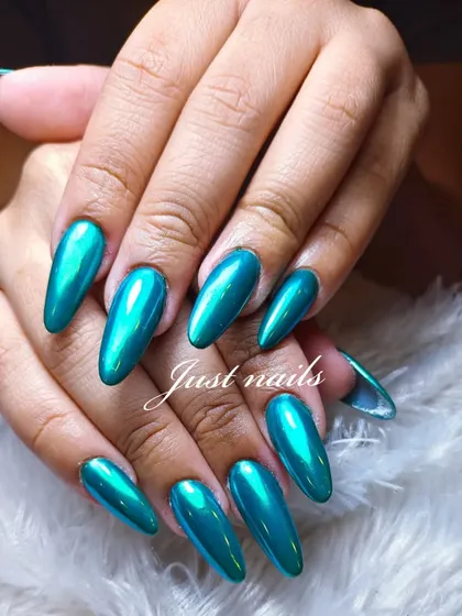 A mesmerizing metallic green chrome finish on long, almond-shaped nail extensions. This look is sleek, futuristic, and guaranteed to turn heads.