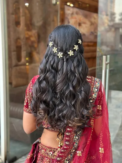 A half-updo with a waterfall braid effect, decorated with small, sparkling flower clips.
