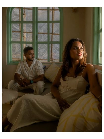 A beautifully lit, moody portrait of the couple inside a cafe. Her gaze out the window and the soft light create a thoughtful and cinematic feel.