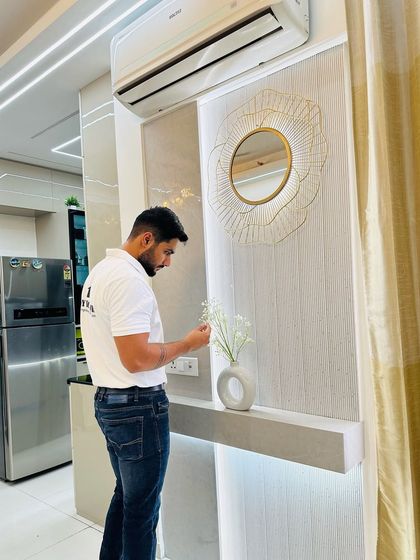 A close-up of a decorative wall niche with a floating shelf. This small detail, complete with a stylish mirror and vase, adds a touch of elegance to a corner.