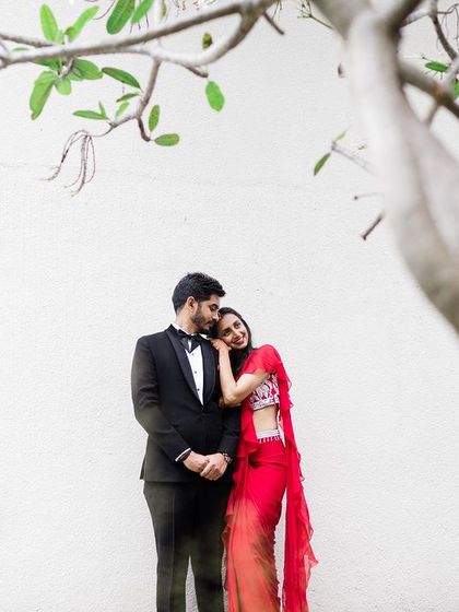 A duplicate of image 77, a romantic portrait of a couple in formal attire, framed by the branches of a tree.