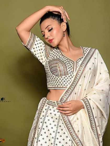 An artistic pose that highlights the blouse design and the model's elegant hands.