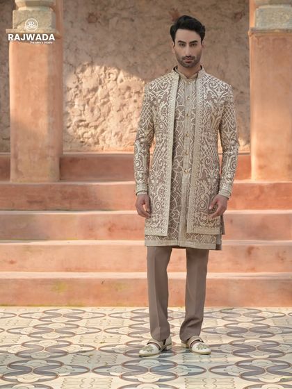 The complete beige Indo-Western outfit, showcasing the layered look. The combination of the embroidered jacket and kurta creates a rich, textured, and royal appearance.